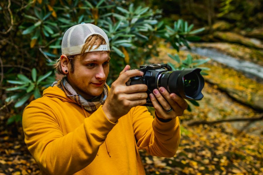 Man in yellow shirt and white hat taking a photo