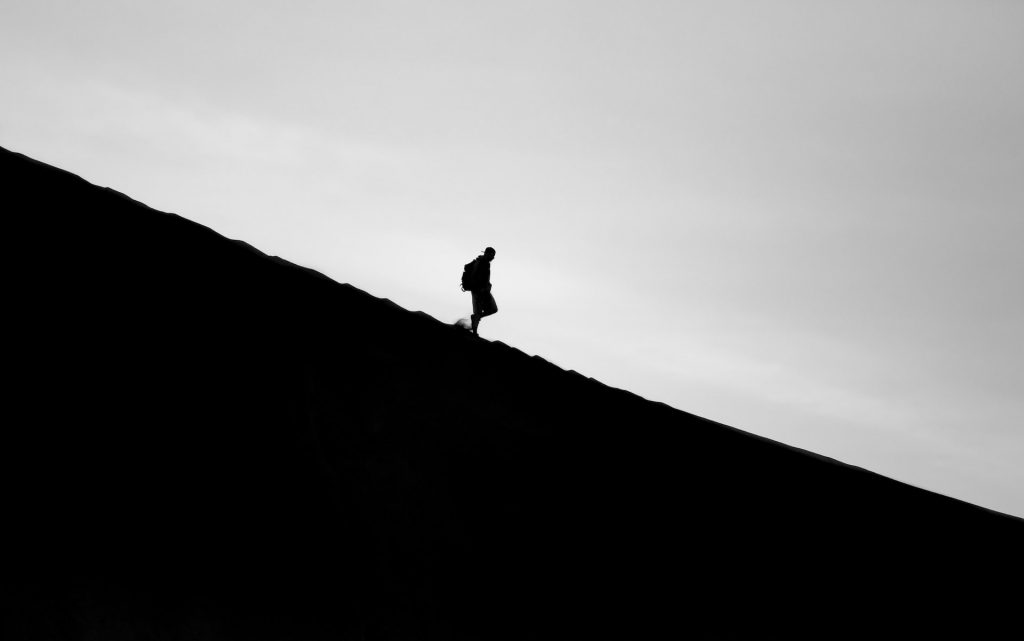 silhouette of a person hiking downhill